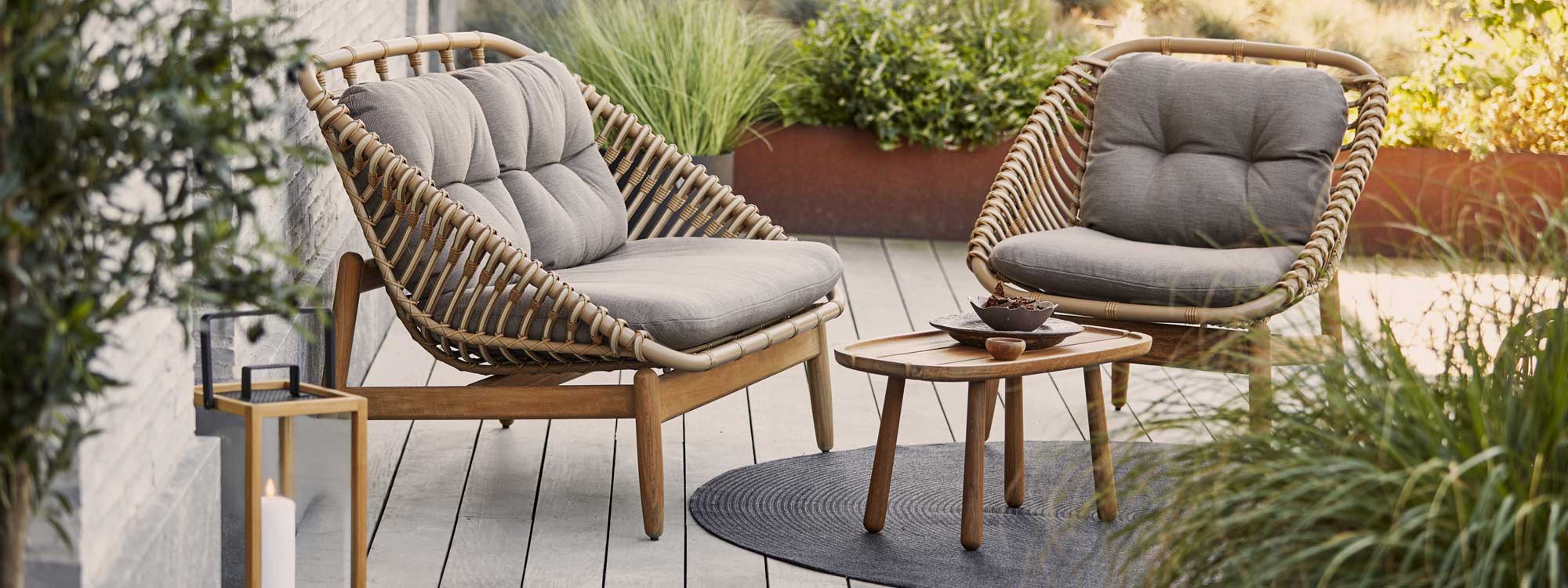 Image of Cane-line Strington 2 seat sofa and garden lounge chair, shown in Cane-line weave, which looks like natural cane.