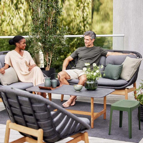 Image of couple relaxing in grey SoftRope Strington garden sofa and lounge chair by Cane-line