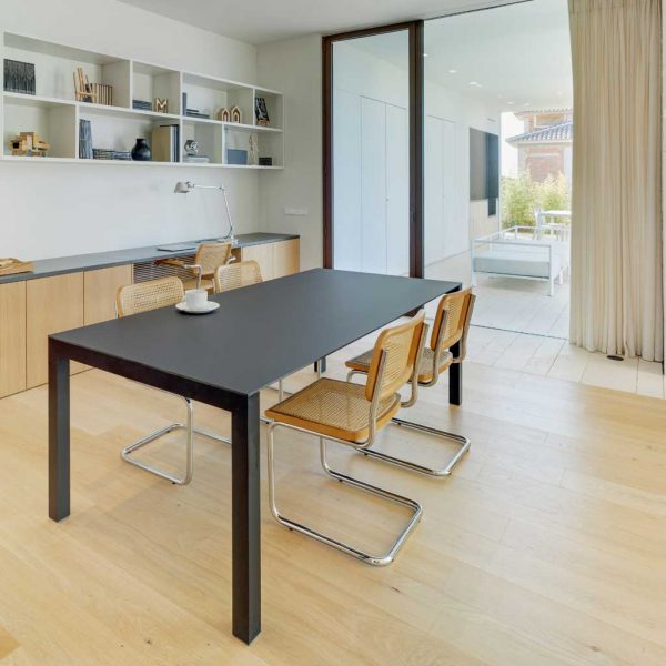 Image of Oiside 45 rectangular garden table in black colour finish, shown inside a house with cantilever chairs around the table