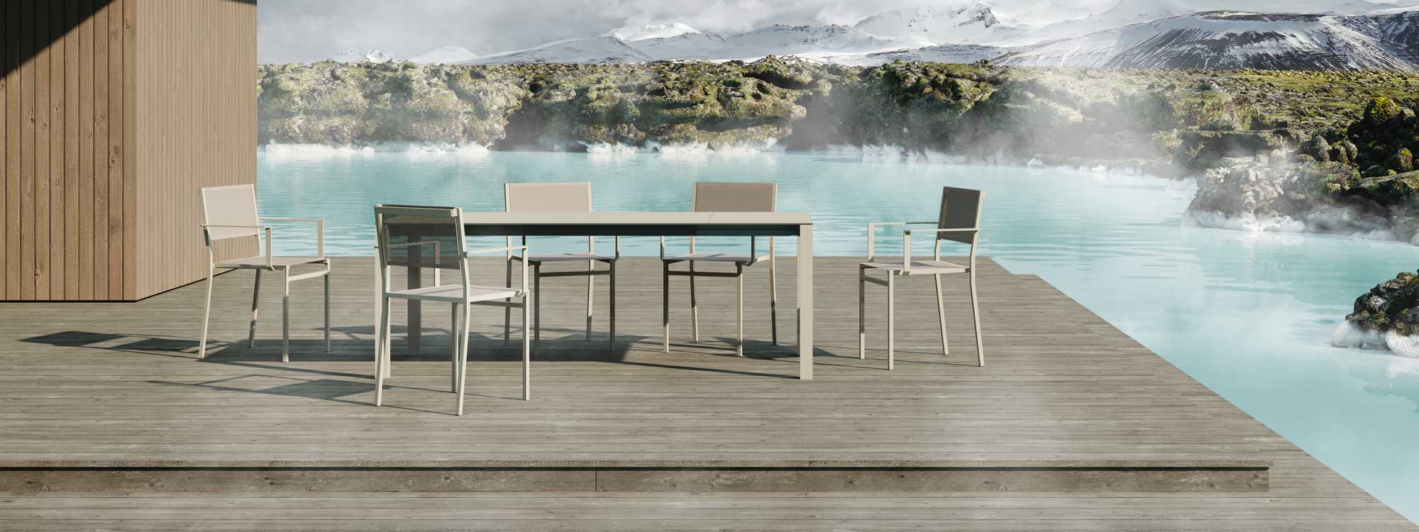 Image of 45 extending garden table and minimalist garden chairs by Oiside, shown on wooden decking with chilly lake and snowy mountains in the background