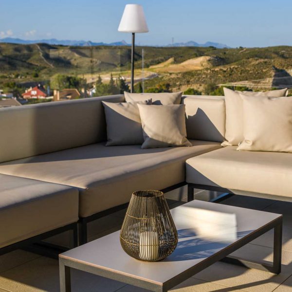 Image of Oiside Línea modern garden sofa and outdoor low table on terrace, with hills in the background