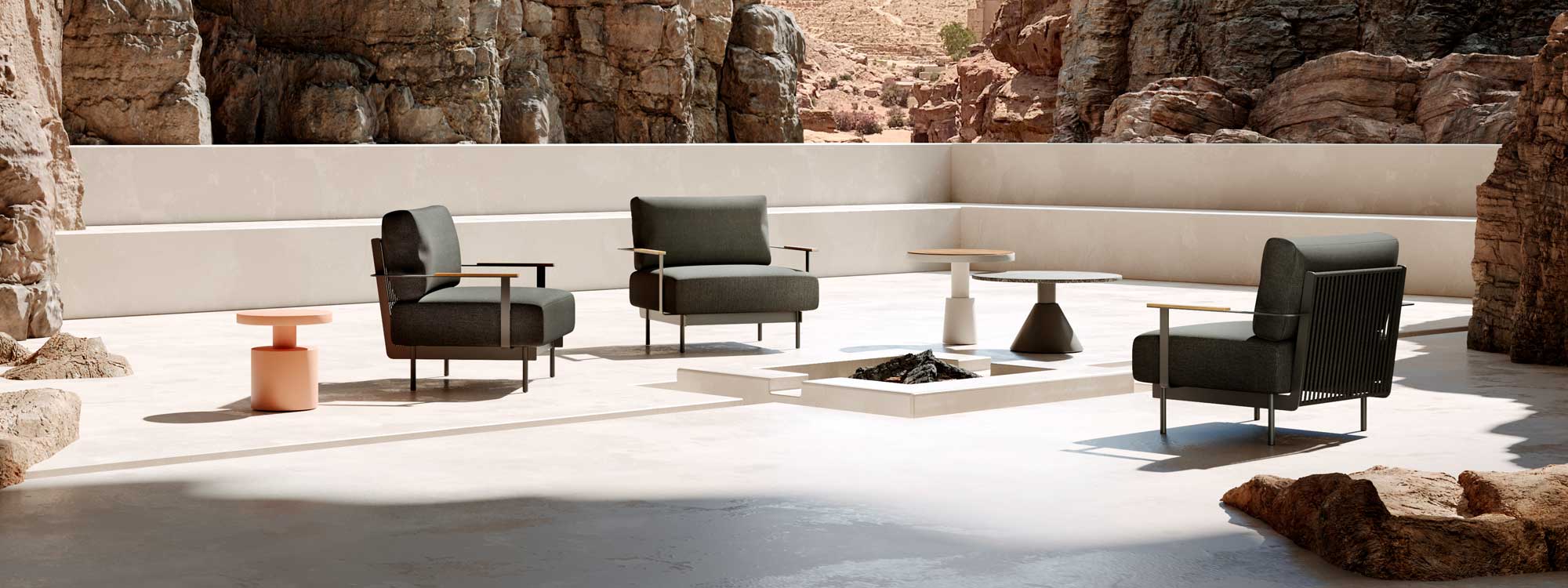 Image of Oiside Penda modern garden low chairs with Drum tables, shown on whitewashed terrace with rocky canyon in the background