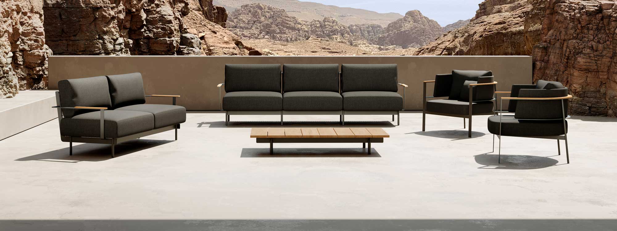 Image of Oisde Penda minimalist garden sofas and lounge chairs on sunny terrace, with arid hilly terrain in the background