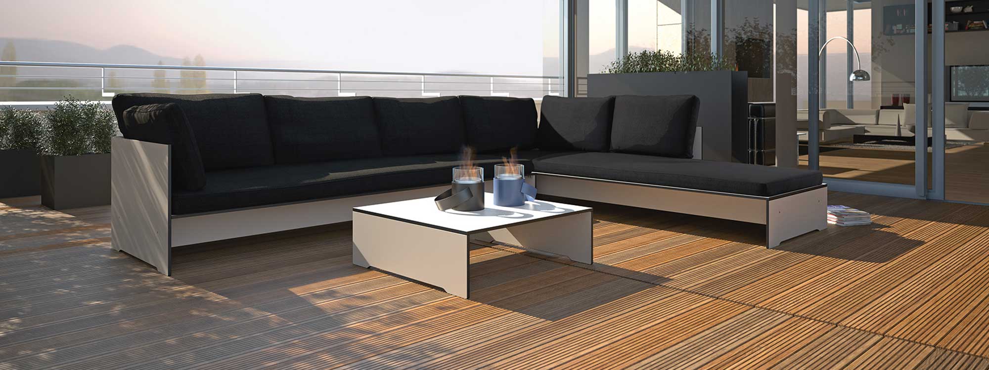 Image of Conmoto Riva white garden corner sofa with anthracite cushions, shown on wooden decking of rooftop terrace