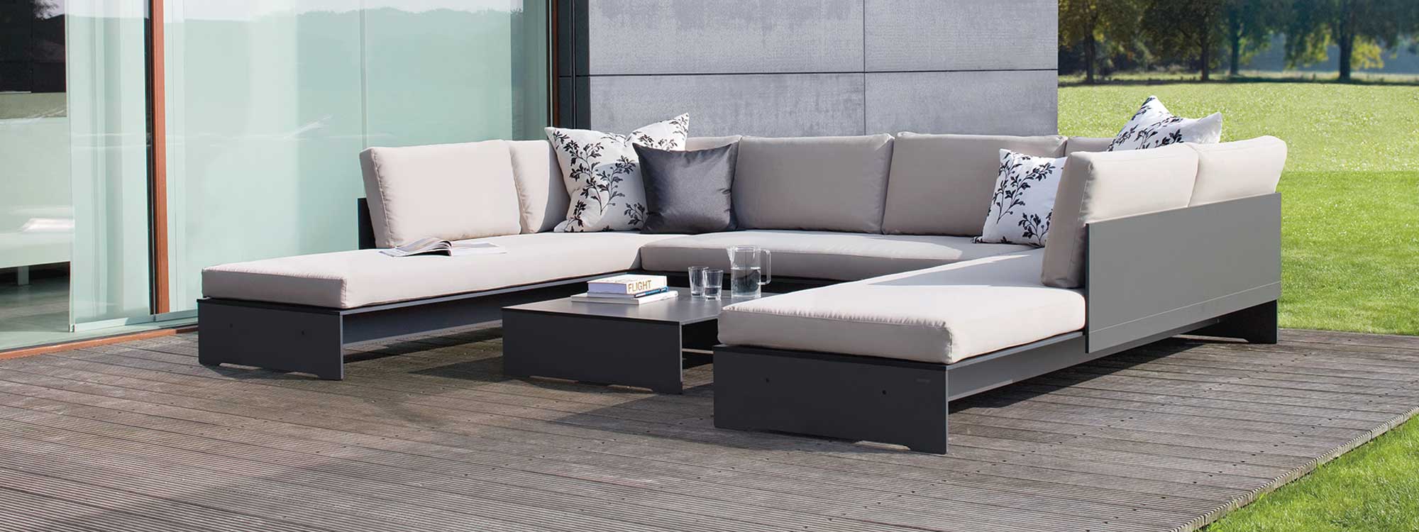 Image of Conmoto Riva U shaped garden sofa in anthracite coloured HPL and light-grey cushions
