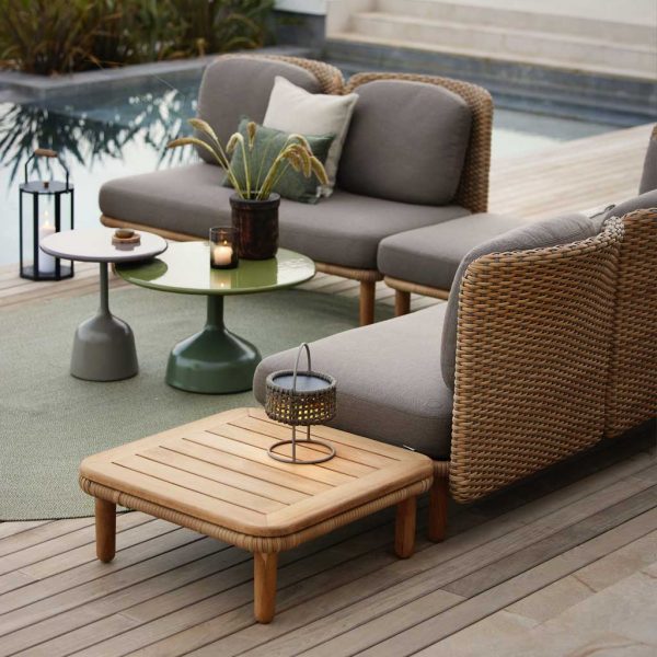 Image from rear of Arch modern rattan corner sofa and Glaze low tables by Cane-line, shown in poolside