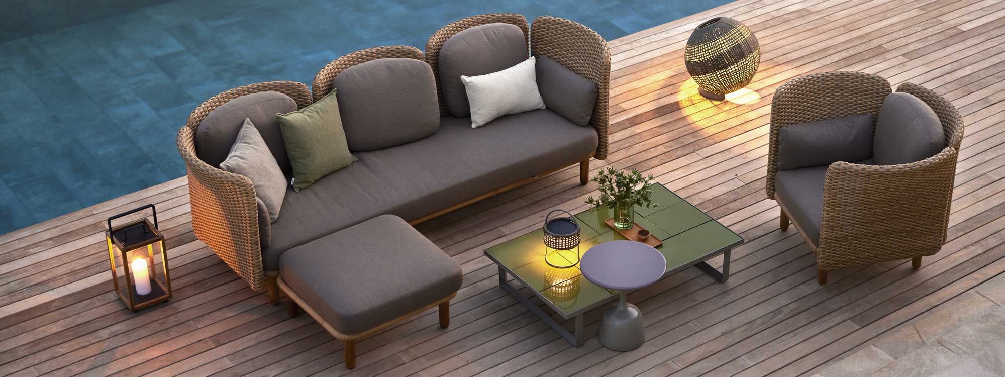Image of aerial view of Cane-line Arch 3 seater modern rattan sofa, footrest and lounge chair on trendy poolside