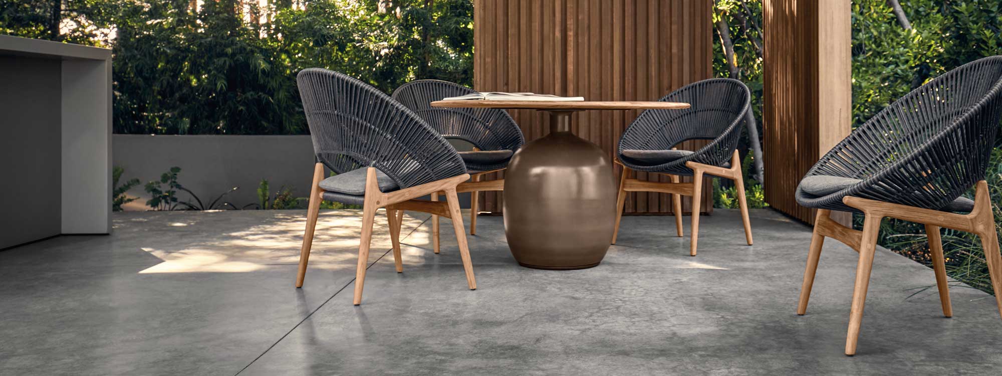 Image of Gloster Bora teak & rope tub chair and Kasha dining table on shady poured concrete terrace