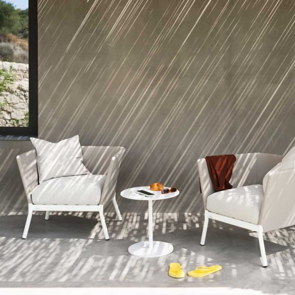 Image of Button modern outdoor side table in between pair of Calla minimalist lounge chairs by RODA