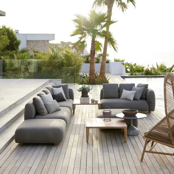 Image of Cane-line Capture upholstered garden sofa on poolside with palm trees in the background