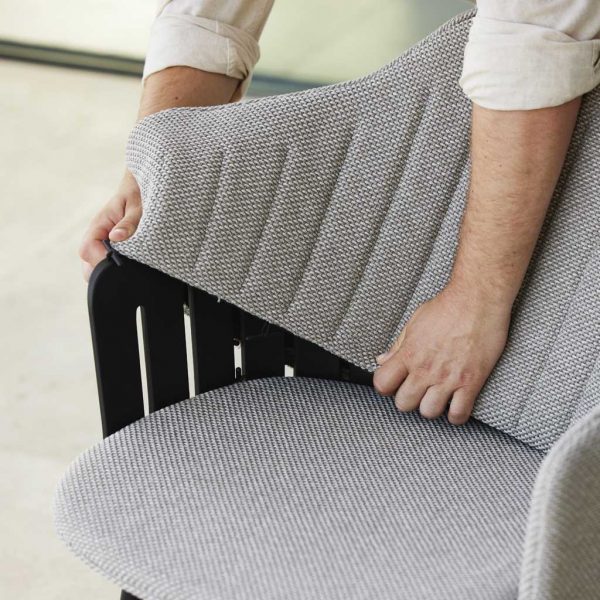 Image of man demonstrating how easy it is to fit upholstery over Choice garden chair's back by Cane-line