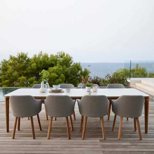 Image of Choice modern teak dining chairs and Aspect long teak garden table with travertine ceramic top by Cane-line