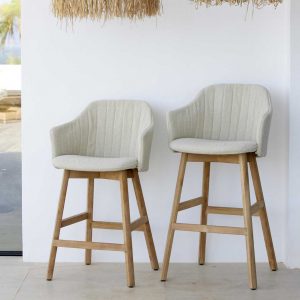 Image of 2 different heights of Choice teak bar stools with snug white seat and back fabric upholstery by Cane-line