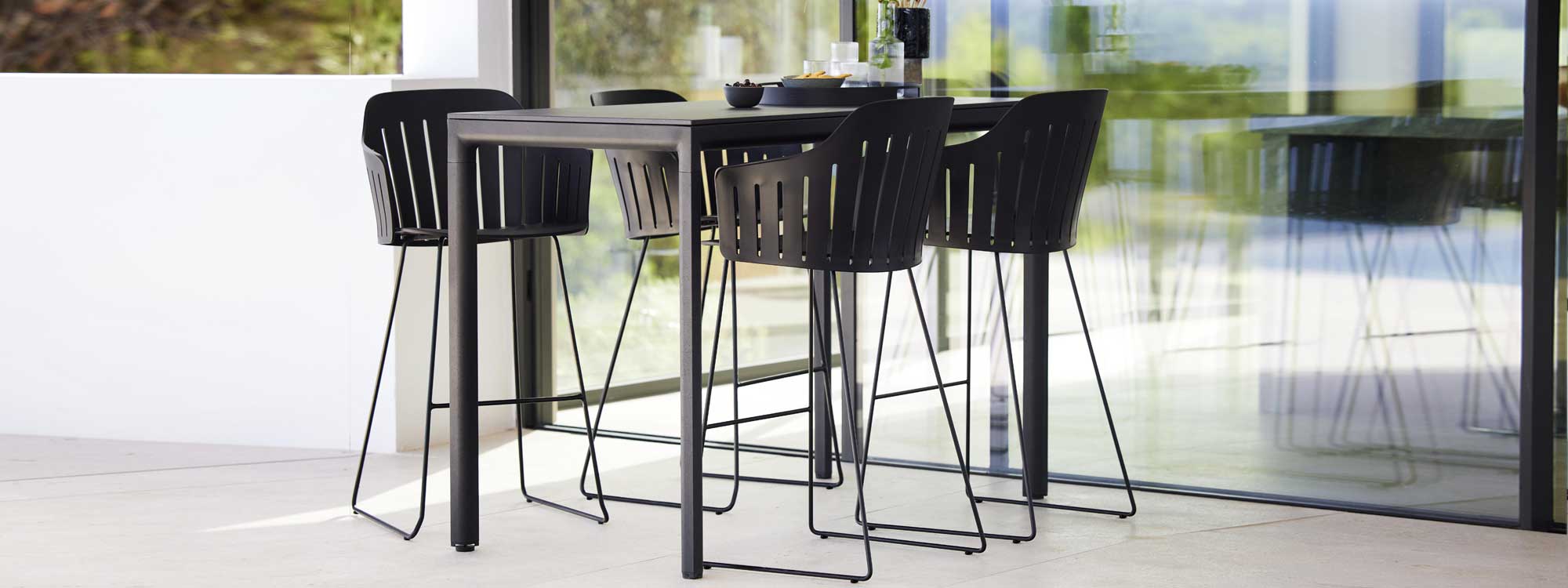 Image of Choice bar stools with recycled polypropylene seat shell and powder coated galvanised legs with Drop bar table by Cane-line