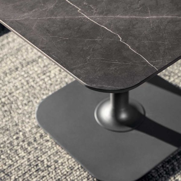 Image of detail of Grid low garden dining table's Nero ceramic tablle top and Meteor-grey aluminium base by Gloster