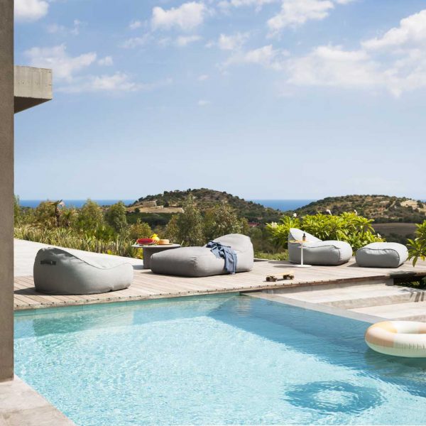 Image of RODA Onda modern garden beanbags on sunny poolside, with undulating Italian countryside in the background