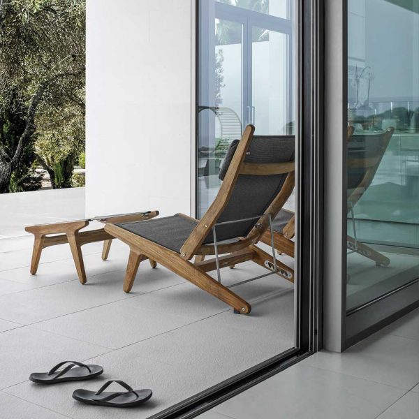 Image of rear of Bay modern garden recliner and footstool by Gloster on minimalist terrace