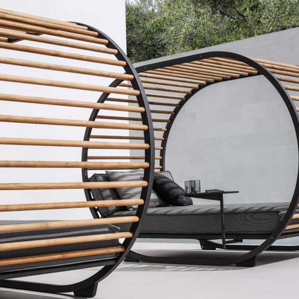 Image of pair of Gloster Cradle Lounge modern cabana daybeds with grey cushions on sleek terrace