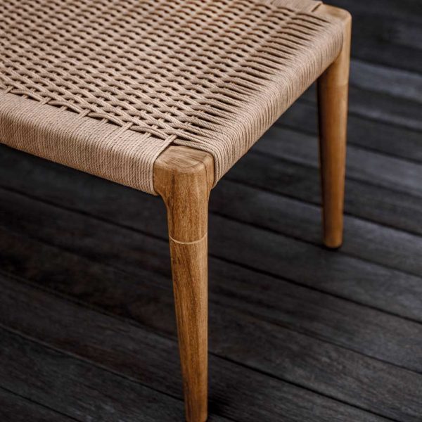 Image of detail of Gloster Lima's tapered teak legs and hand-woven all-weather wicker seat surface