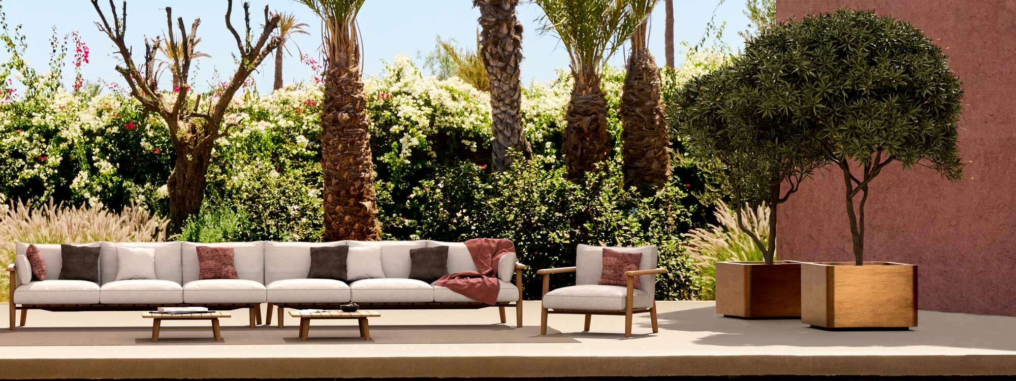 Image of large Mambo luxury garden sofa and Cuprum large cube planters, with palms and exotic trees in the background