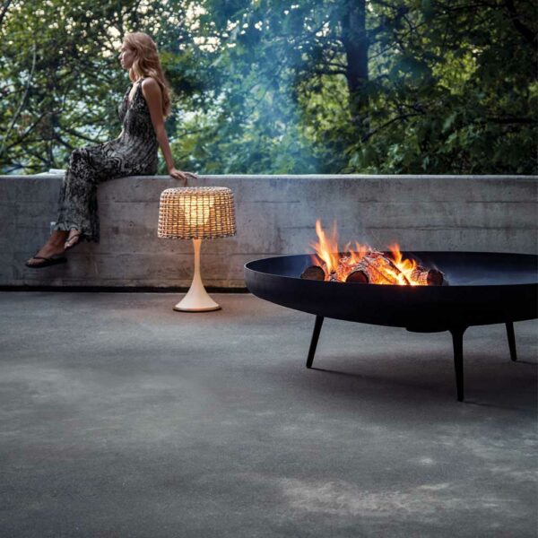Image of Gloster modern Fire Bowl on sultry terrace with woman say on concrete wall in the background