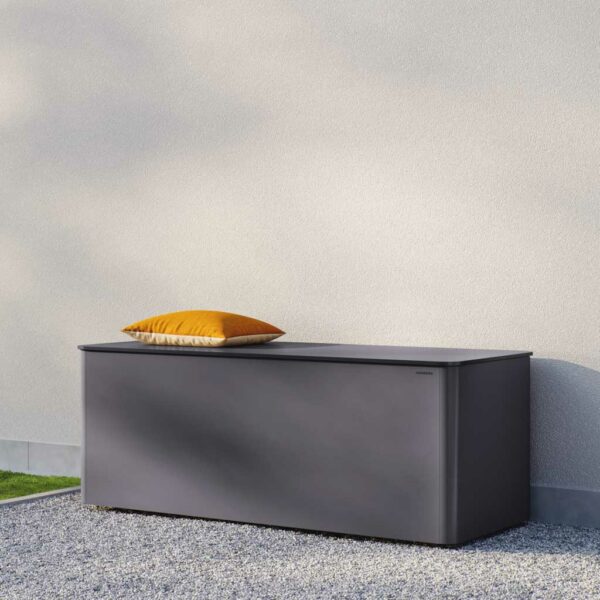 Image of Conmoto Ronda modern garden cushion chest in grey HPL shown on gravel against a wall