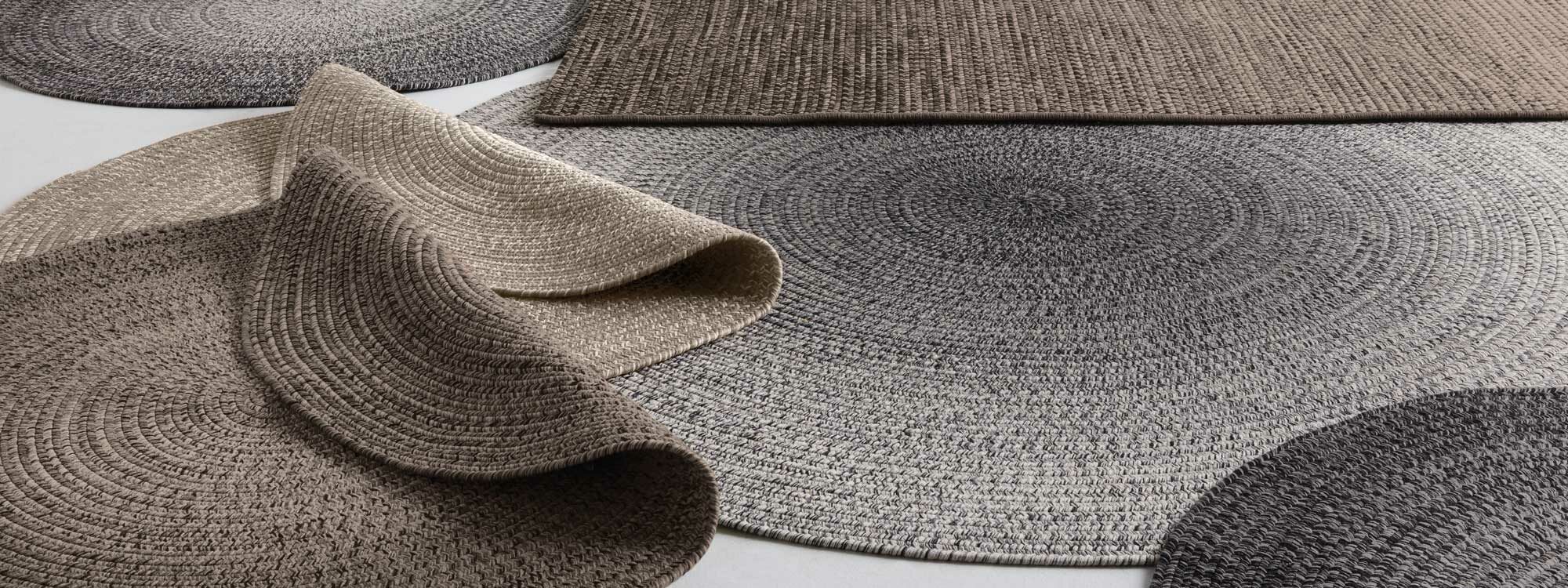 Studio image of round & rectangular Gloster garden rugs and carpets laid over one another