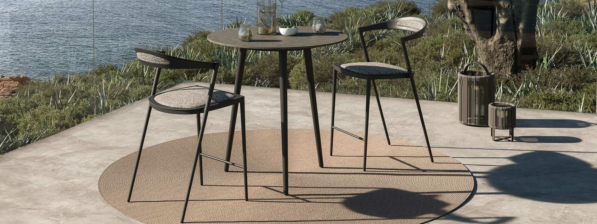 Image of Royal Botania Styletto high bar table and bar stools on sunny terrace overlooking the sea