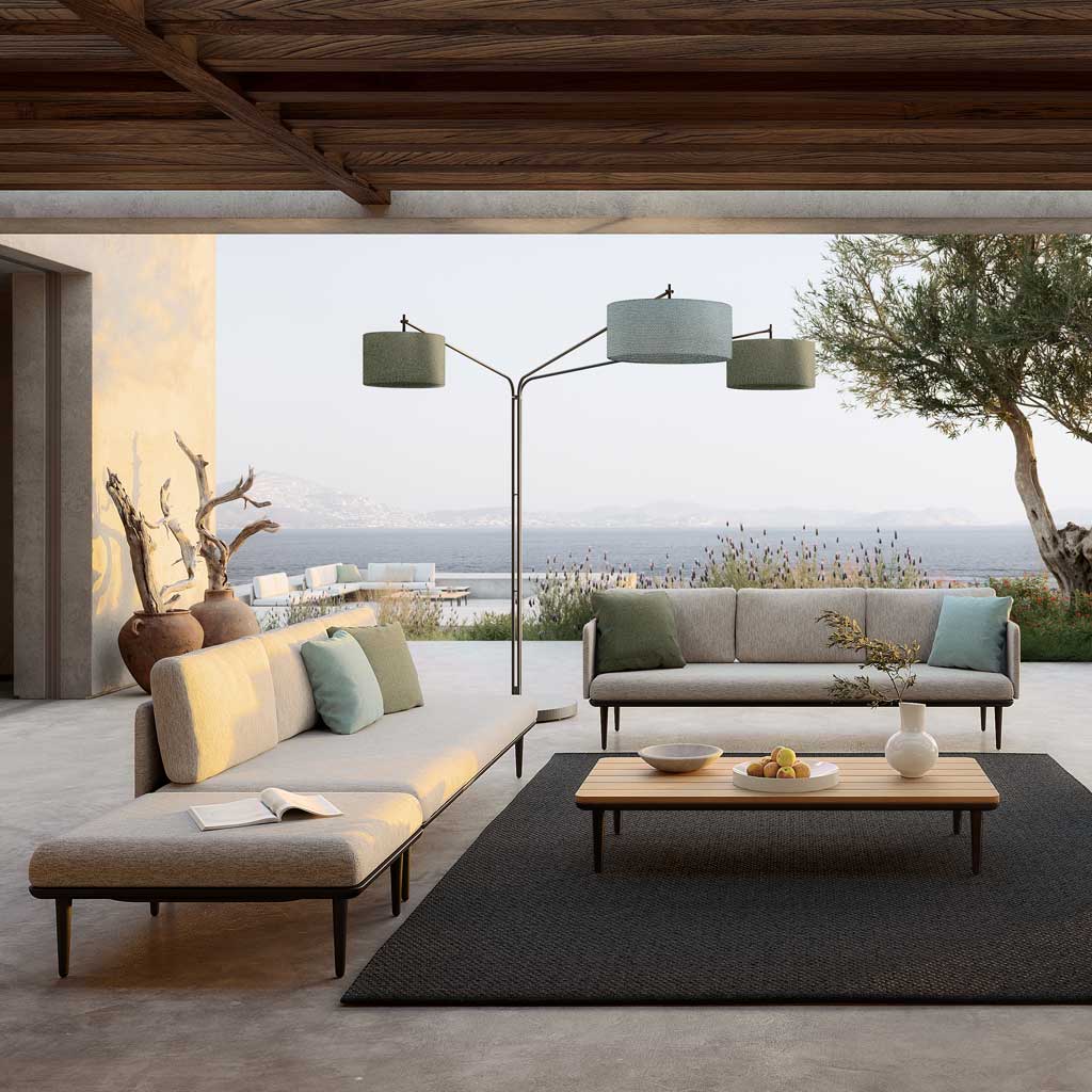 Image of Royal Botania Luniz outdoor floor lamp and Styletto Lounge outdoor sofa on terrace with olive tree and the sea in the background