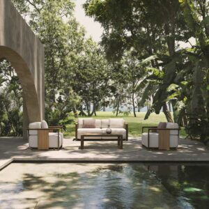 Image of Vondom Tulum garden sofa and lounge chairs next to peaceful water feature, with banana plants, trees and lawn in the background