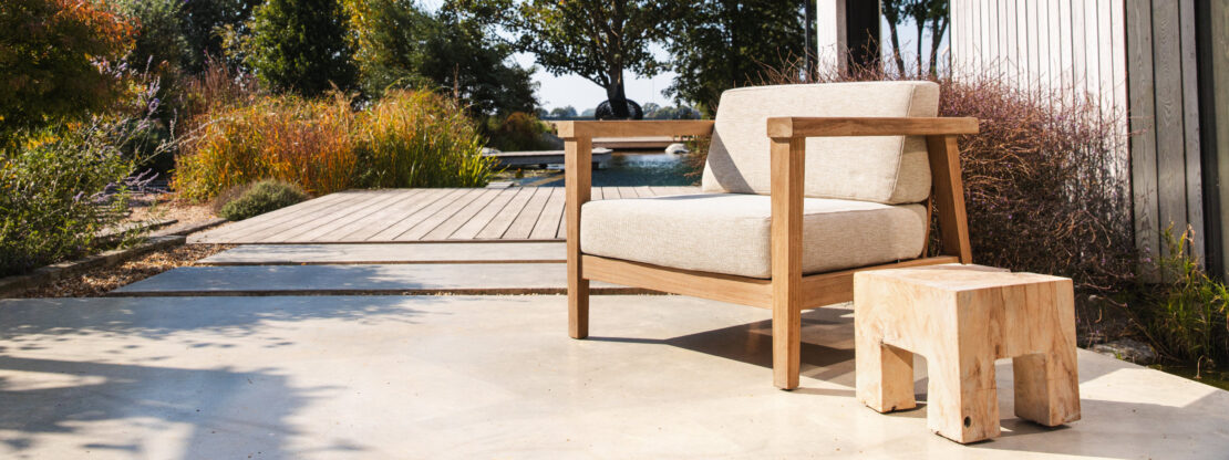 Image of Gommaire 1 seater Copenhague lounge chair with inviting natural swimming pool in the background at the Watershed Bosham