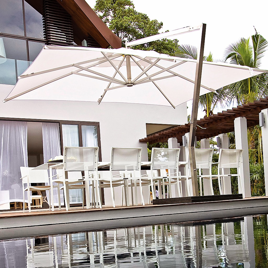 Image of large white Shady X-Centric side post parasol over Royal Botania garden dining furniture