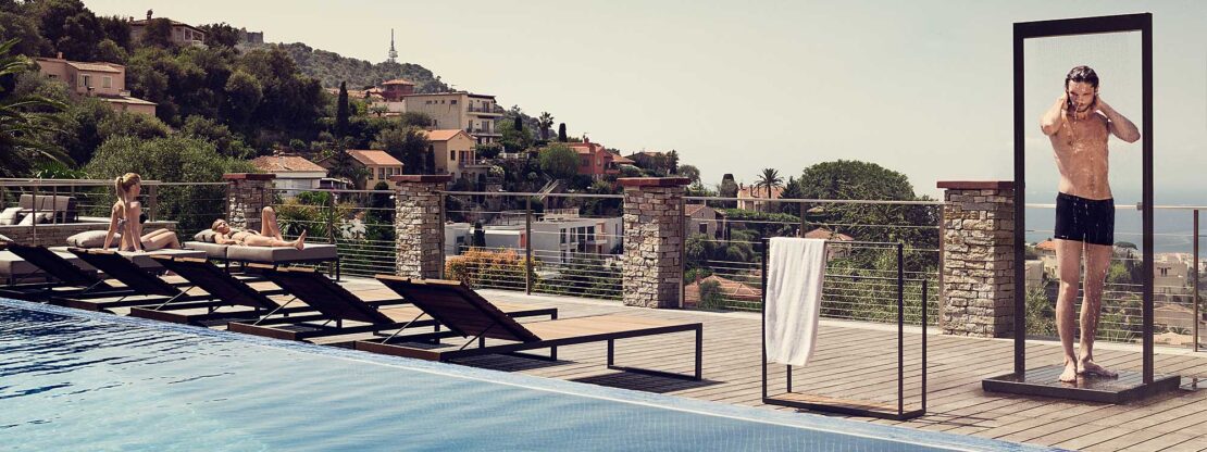 Image of dude wearing budgie smuggler swimming trunks, having a wash beneath Roshults Garden Shower on terrace