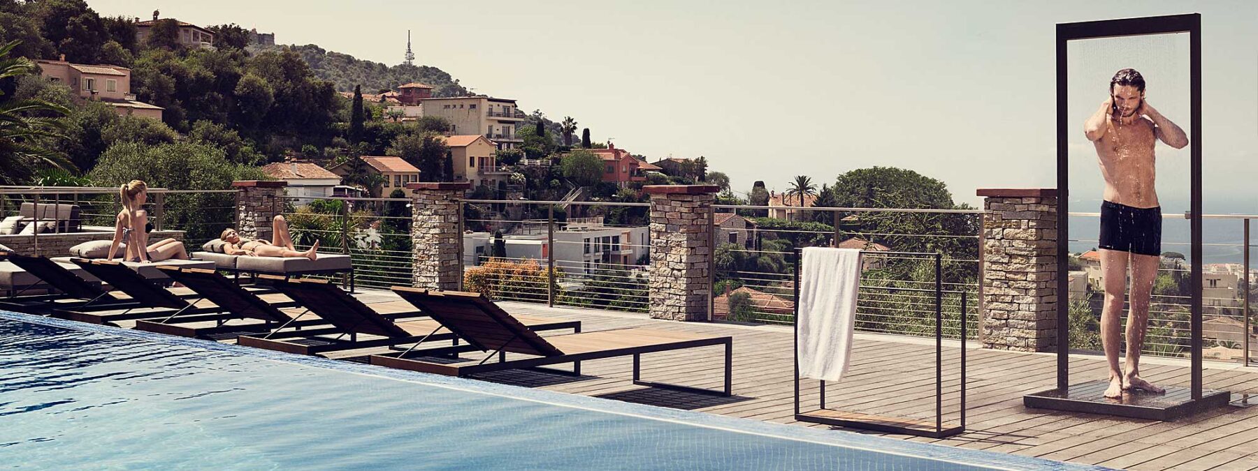 Image of dude wearing budgie smuggler swimming trunks, having a wash beneath Roshults Garden Shower on terrace