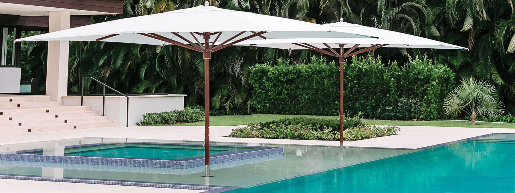 Image of pair of Tuuci Ocean Master Max centre mast parasols with Aluma-Teak mast and ribs, installed in shallow water of swimming pool