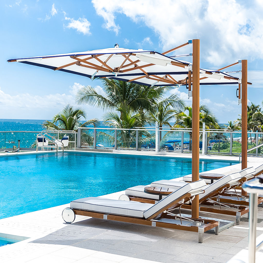 Image of row of Tuuci Ocean Master Max side post parasols with Aluma-Crete wood-effect mast and ribs and white canopy, with G-Plate galvanised steel bases