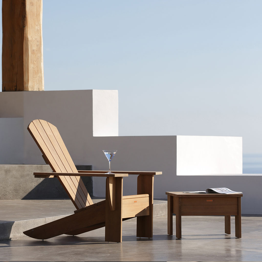 Image of New England teak recliner with cocktail glass resting on arm by Royal Botania furnture