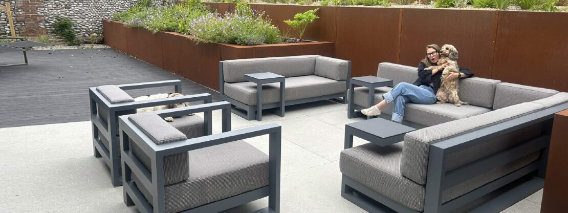 Image of Vondom Posidonia minimalist garden sofa in traffic grey, shown against oxidised corten steel terracing