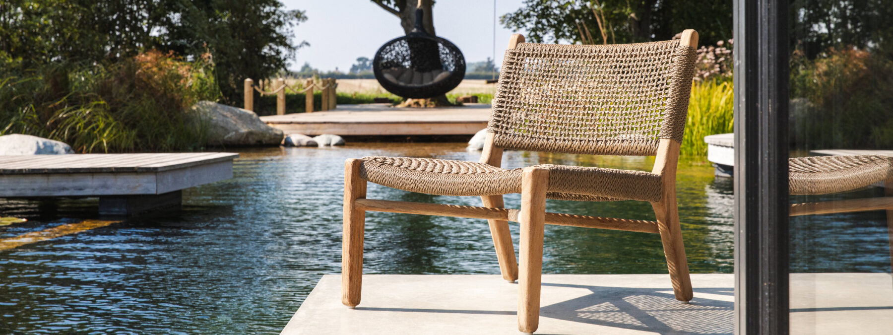Image of Gommaire Fiona easy chair on concrete decking with Bios Hide swing seat in the background at the Watershed Bosham