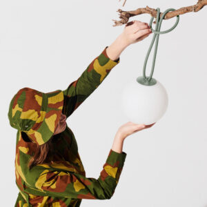 Image of a woman hanging a Fatboy Bolleke lantern from a branch