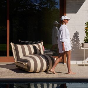 Image of woman walking past Fatboy Bonbaron outdoor lounge chair on poolside